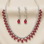 Jewelry set with red gemstones and silver accents on a beige background