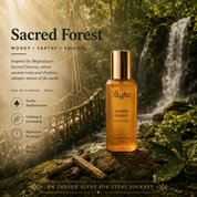 A bottle of Elyta Sacred Forest Sandalwood Eau de Parfum stands on a mossy log in a forest scene with a waterfall in the background from Meghalaya. The bottle is amber glass with a metallic gold cap and a gold label.
