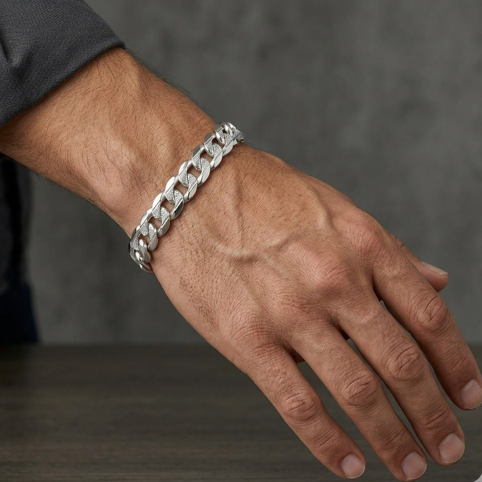 Hand wearing a silver chain bracelet on a dark background